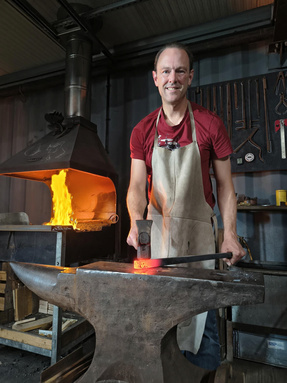 Jim P. Ballard hammering a red hot steel bar in the forge
